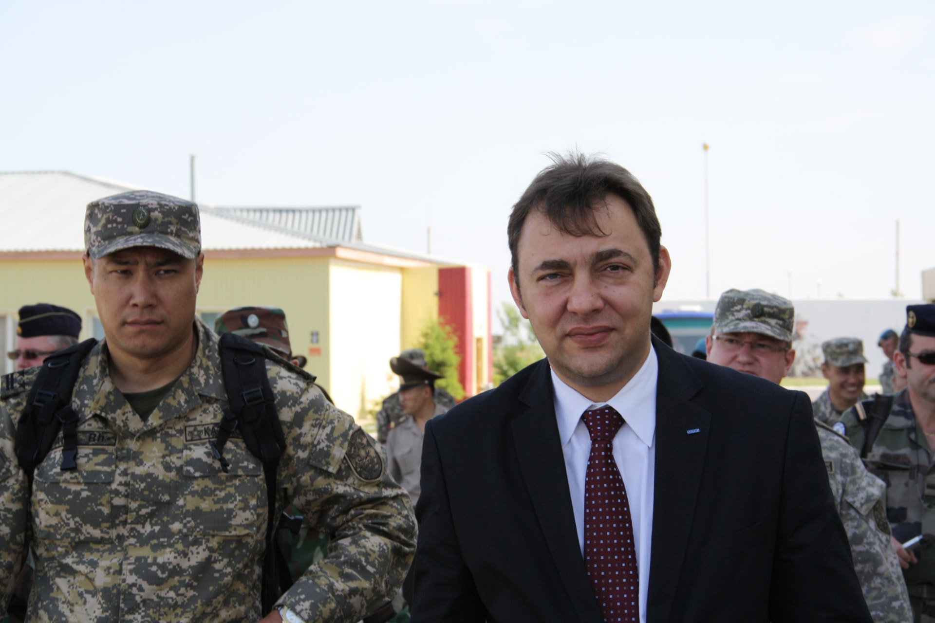 Andrei Muntean arriving at a multinational field deployment alongside uniformed personnel